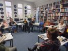 Zdjęcie przedstawia ludzi w bibliotece