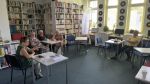 Zdjęcie przedstawia ludzi w bibliotece