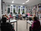 Zdjęcie przedstawia ludzi w bibliotece