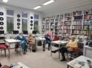Zdjęcie przedstawia ludzi w bibliotece