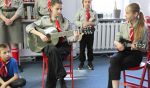 Dwie dziewczynki grają na gitarze i śpiewają w bibliotece