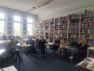 Zdjęcie przedstawia ludzi w bibliotece