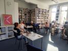 Zdjęcie przedstawia ludzi w bibliotece