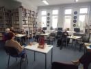 Zdjęcie przedstawia ludzi w bibliotece