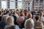 Zdjęcie przedstawia ludzi w bibliotece