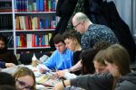 Zdjęcie przedstawia ludzi w bibliotece