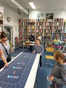 Zdjęcie przedstawia grupę osób grających w kapsle