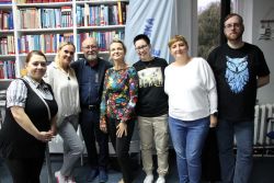 Zdjęcie przedstawia ludzi w bibliotece