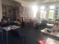 Zdjęcie przedstawia ludzi w bibliotece