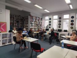 Zdjęcie przedstawia ludzi w bibliotece