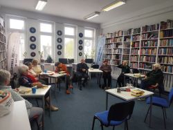 Zdjęcie przedstawia ludzi w bibliotece