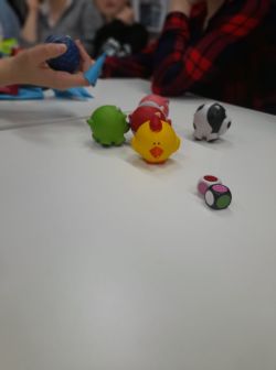 Zdjęcie przedstawia grających w grę planszową w bibliotece.