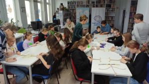 Zdjęcie przedstawia dzieci i młodzież podczas warsztatów makramowych