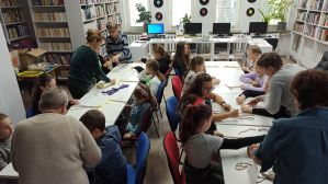 Zdjęcie przedstawia dzieci i młodzież podczas warsztatów makramowych