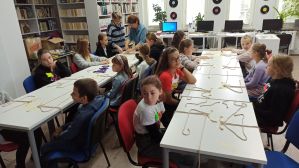 Zdjęcie przedstawia dzieci i młodzież podczas warsztatów makramowych