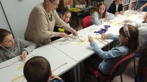 Zdjęcie przedstawia dzieci i młodzież podczas warsztatów makramowych