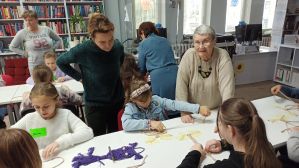 Zdjęcie przedstawia dzieci i młodzież podczas warsztatów makramowych