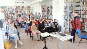 Zdjęcie przedstawia ludzi w bibliotece