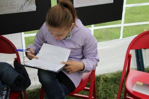 Zdjęcie Pani rozwiązującej krzyżówkę przygotowaną na Narodowe Czytanie