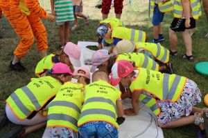 Dzieci kolorują baner na którym są narysowane duże owoce