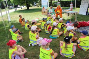 Dzieci siedząc na trawie słuchają wiersza czytanego przez Tygrysa, Biedronka się poddała i poszła spać