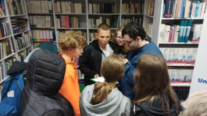 Zdjęcie przedstawia ludzi w Bibliotece.