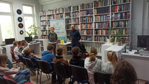 Zdjęcie przedstawia ludzi w Bibliotece.