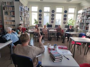 Zdjęcie przedstawia ludzi w bibliotece