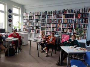 Zdjęcie przedstawia ludzi w bibliotece