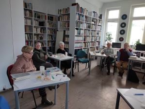 Zdjęcie przedstawia ludzi w bibliotece