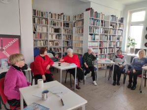 Zdjęcie przedstawia ludzi w bibliotece