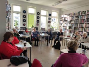Zdjęcie przedstawia ludzi w bibliotece