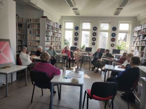 Zdjęcie przedstawia ludzi w bibliotece