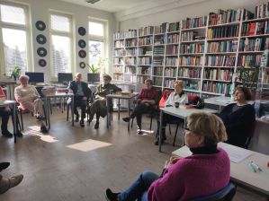 Zdjęcie przedstawia ludzi w bibliotece