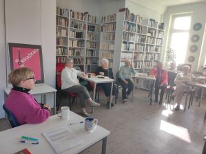 Zdjęcie przedstawia ludzi w bibliotece