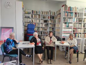 Zdjęcie przedstawia ludzi w bibliotece