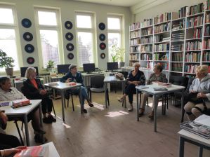 Zdjęcie przedstawia ludzi w bibliotece