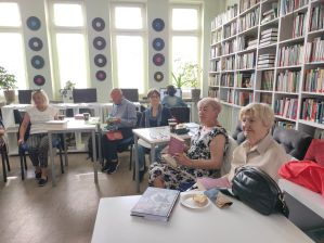 Zdjęcie przedstawia ludzi w bibliotece