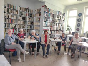 Zdjęcie przedstawia ludzi w bibliotece
