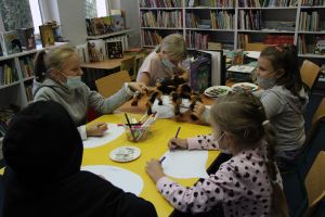 na zdjęciu dzieci wykonują pracę plastyczną