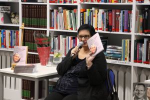 zdjęcie przedstawia kobietę trzymajaca ksiazke