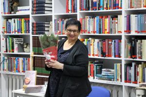 zdjęcie przedstawia kobietę trzymajaca kwiatek