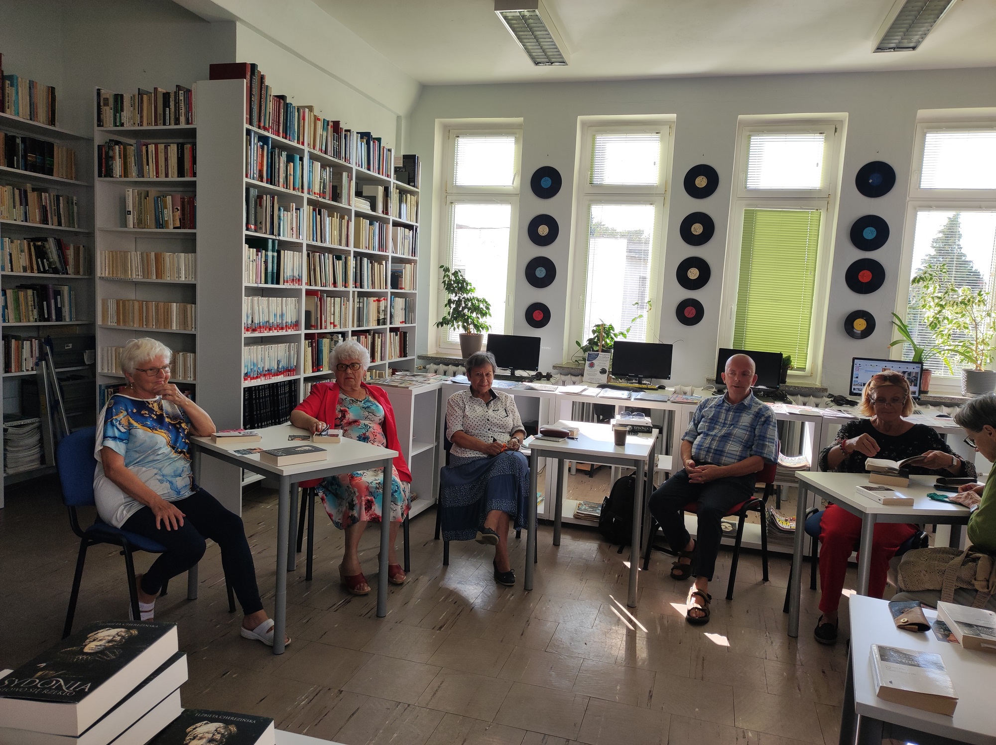 Zdjęcie przedstawia ludzi w bibliotece