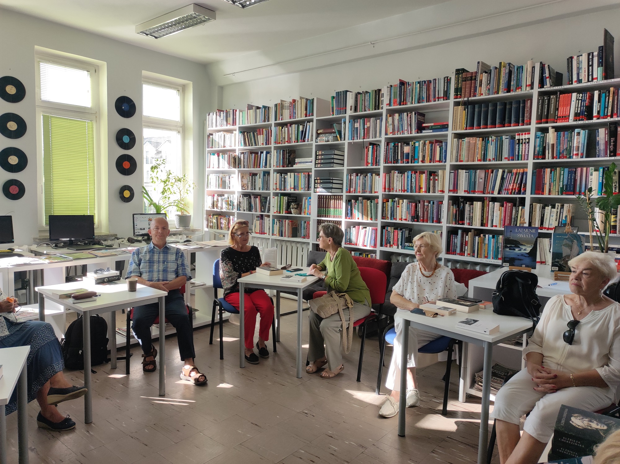 Zdjęcie przedstawia ludzi w bibliotece