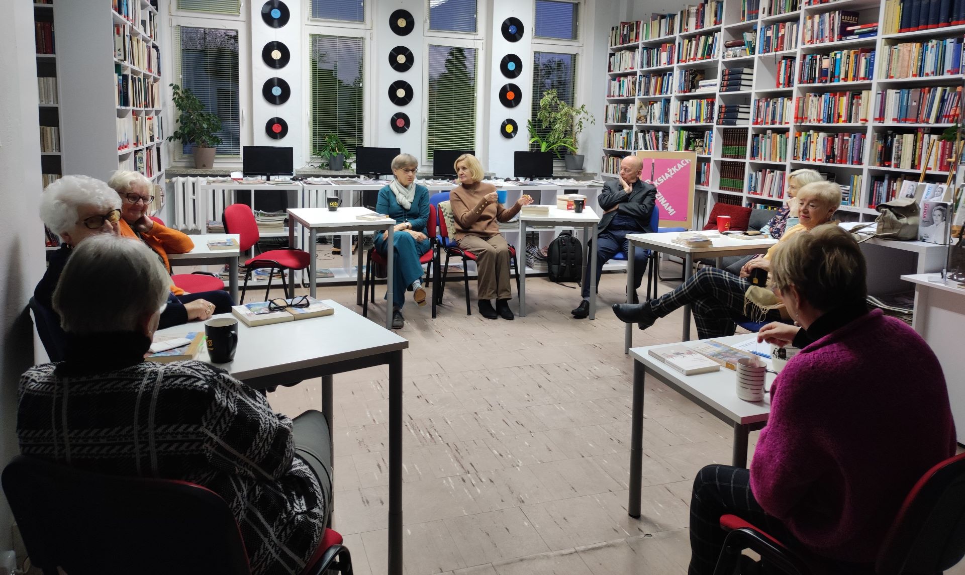 Zdjęcie przedstawia ludzi w bibliotece