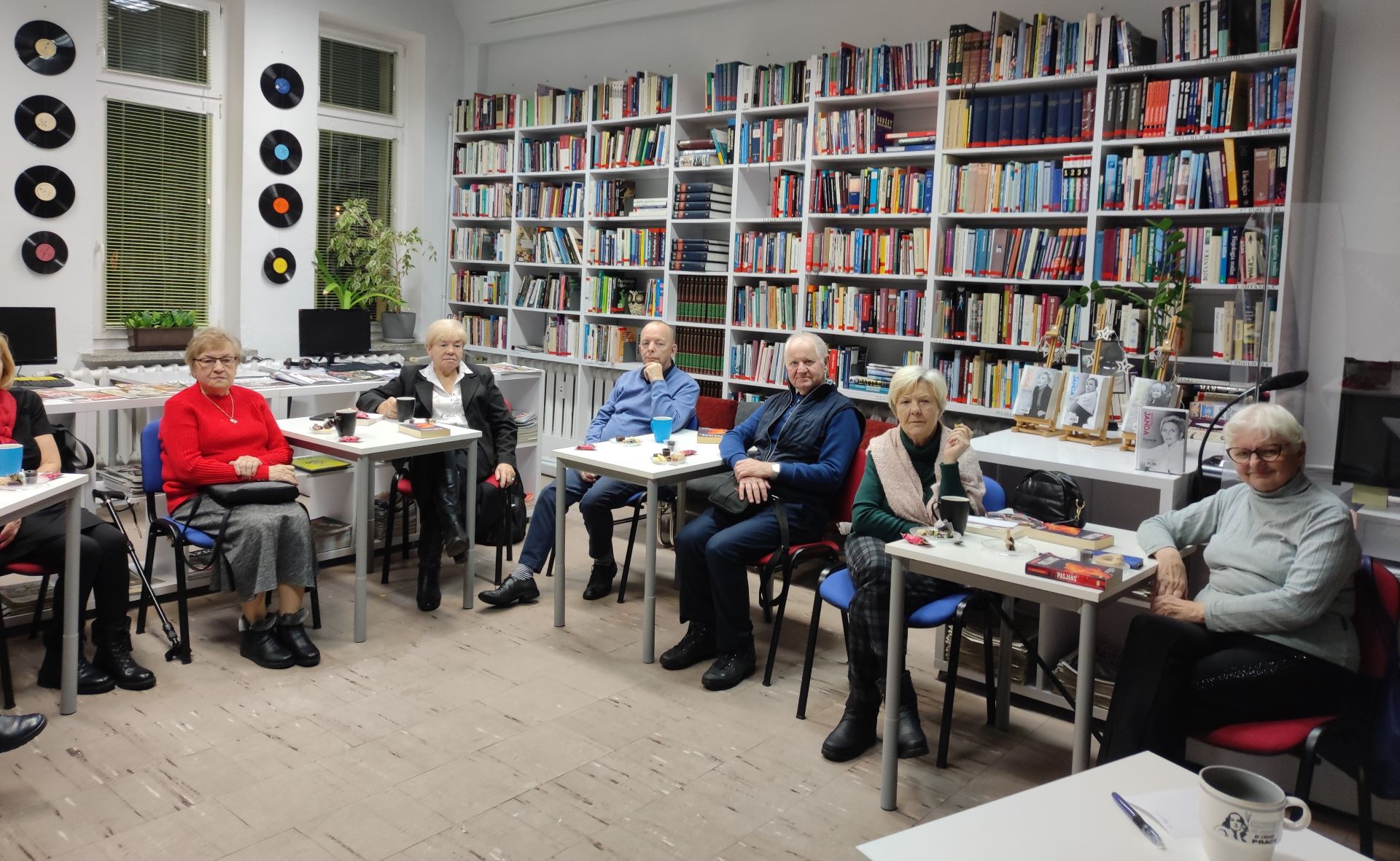 Zdjęcie przedstawia ludzi w bibliotece