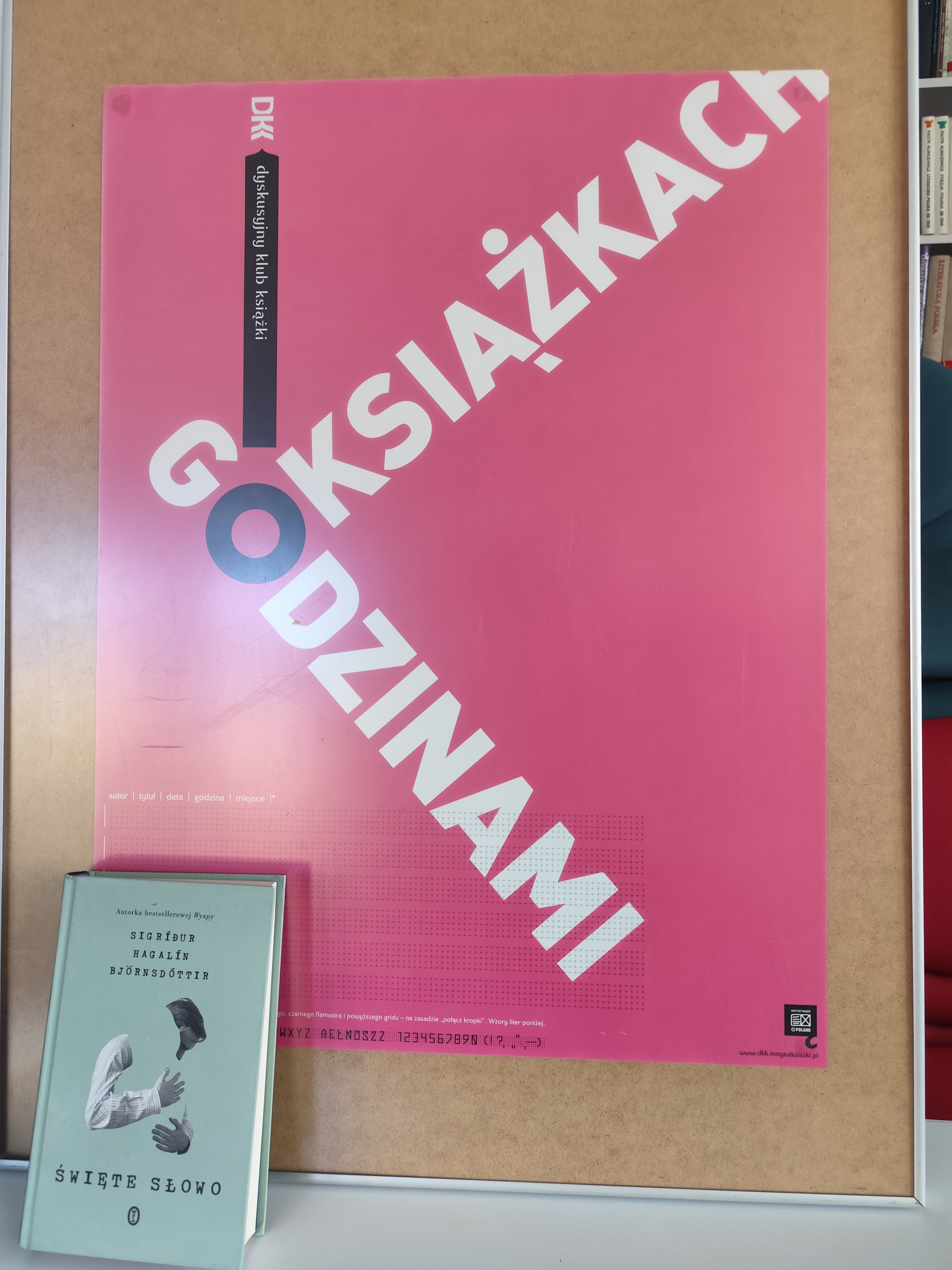 Zdjęcie przedstawia książkę i plakat
