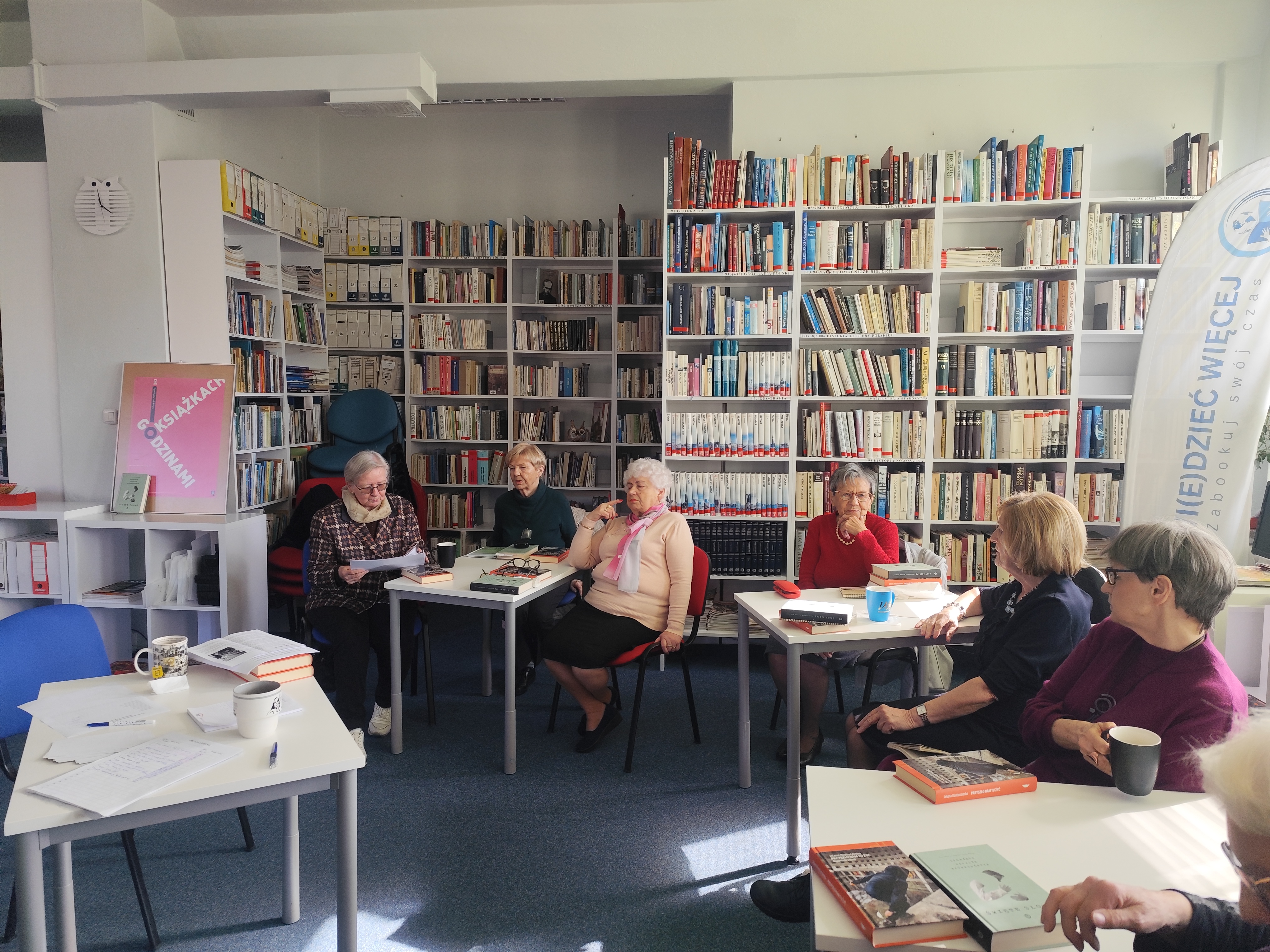 Zdjęcie przedstawia ludzi w bibliotece