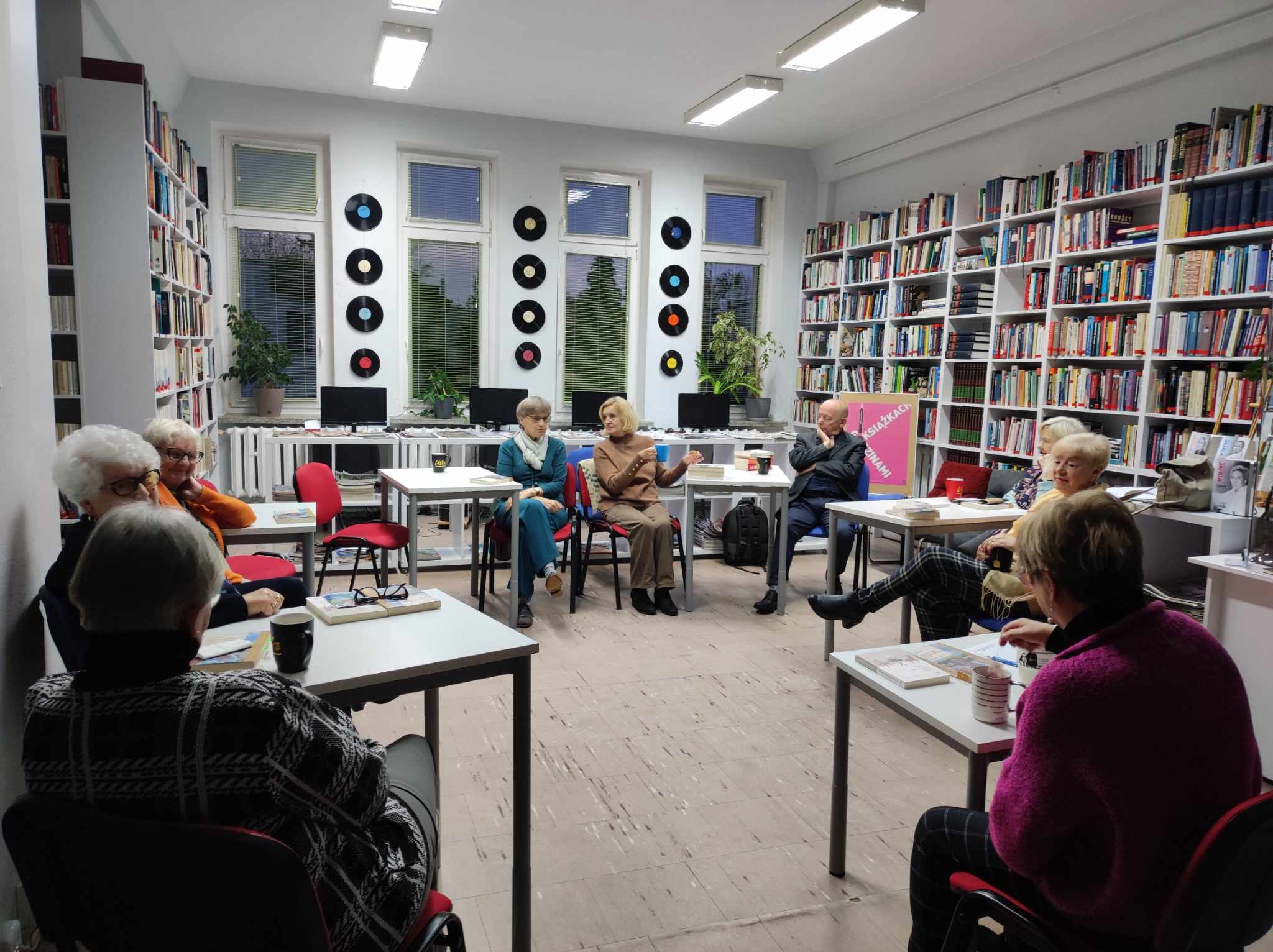 Zdjęcie przedstawia ludzi w bibliotece