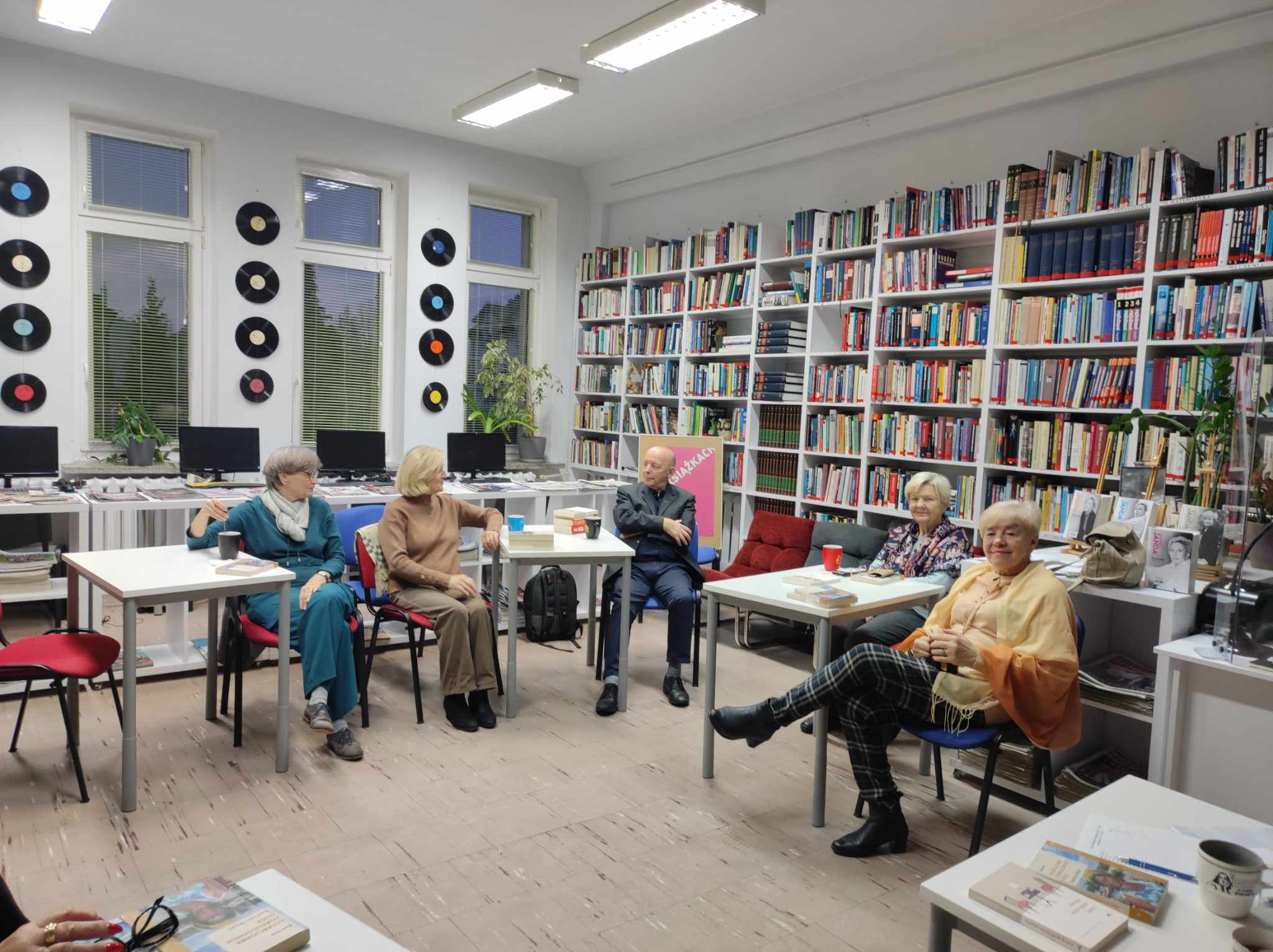 Zdjęcie przedstawia ludzi w bibliotece